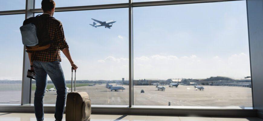 Турист смотрит в окно на самолет